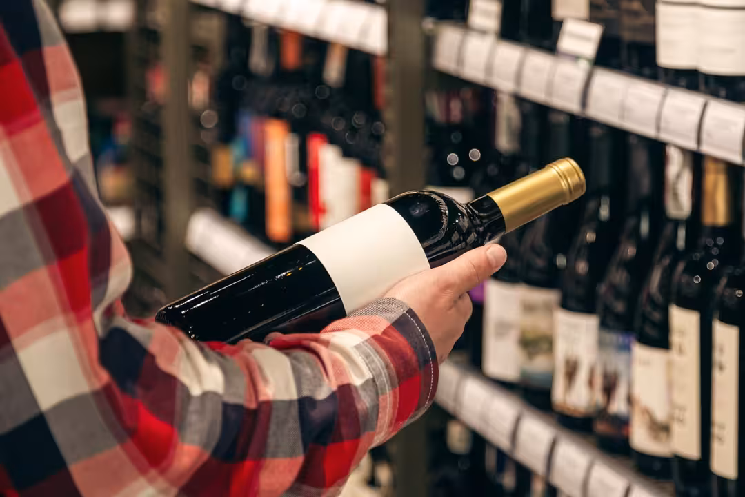Un consumidor seleccionando una botella de vino (Foto FEV)