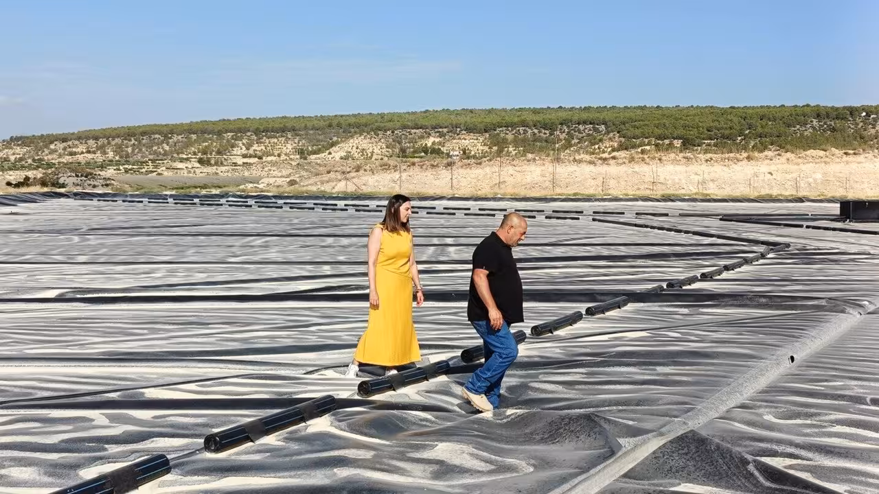 Sara Rubira junto a uno de los beneficiarios de las ayudas con las que ha cubierto el embales de agua sobre el que caminan (Foto CARM)