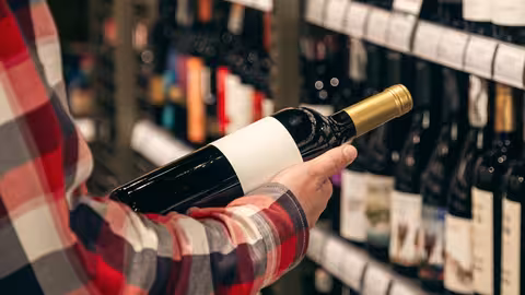 Un consumidor seleccionando una botella de vino (Foto FEV)