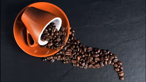 Granos de caf&eacute; en una taza (Imagen de Chris en Pixabay)