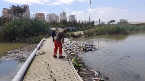 Un operario retira residuos de la desembocadura del r&iacute;o Segura (Foto CHS)