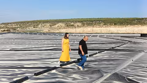 Sara Rubira junto a uno de los beneficiarios de las ayudas con las que ha cubierto el embales de agua sobre el que caminan (Foto CARM)
